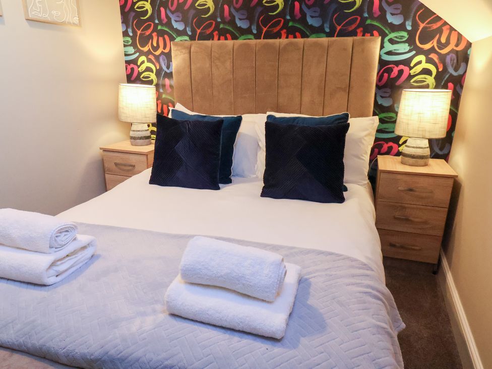 A bedroom with a bed and bedside tables at Crescent Bay House in Filey