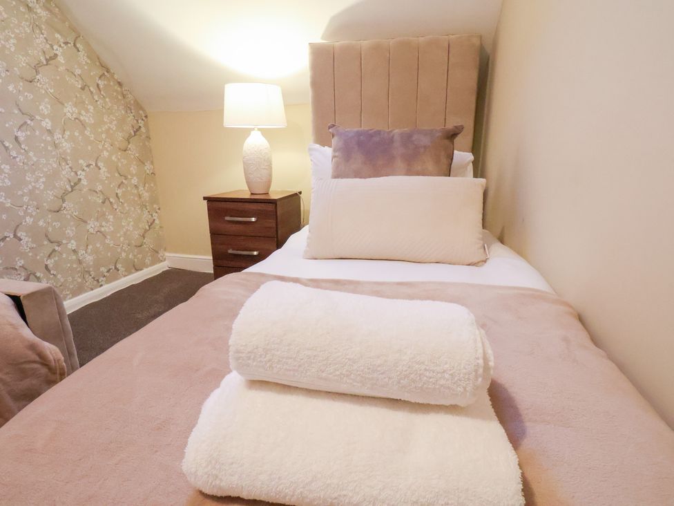 A bedroom with a bed and bedside table at Crescent Bay House in Filey