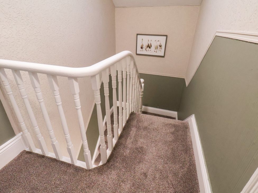 A staircase with a handrail and a framed picture at Crescent Bay House in Filey