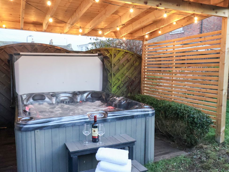 A hot tub with a wine bottle and glasses at Crescent Bay House, Filey