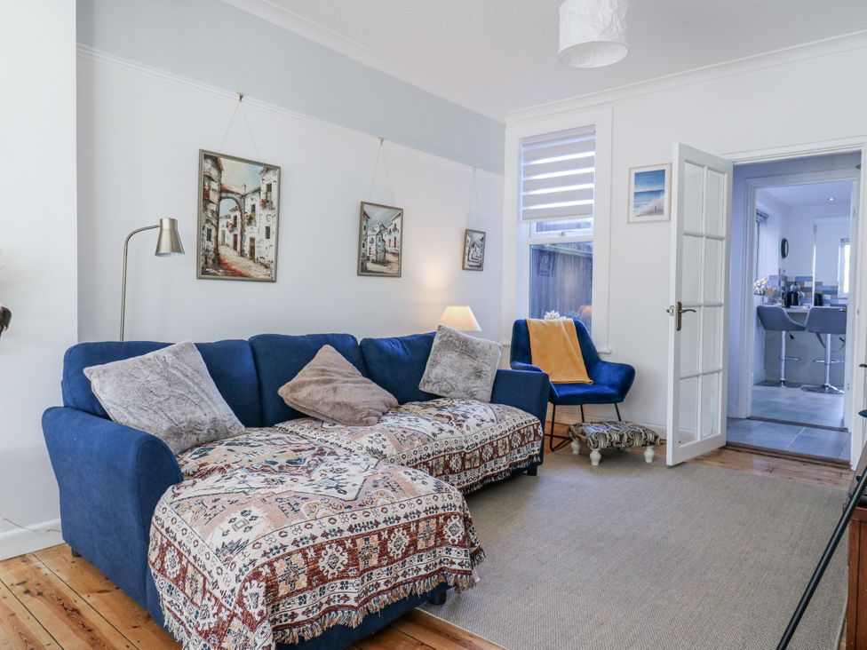 A living room with a blue sofa and armchair at Beachside Terrace Harwich