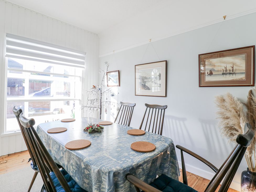A dining room with a table set for six at Beachside Terrace in Harwich