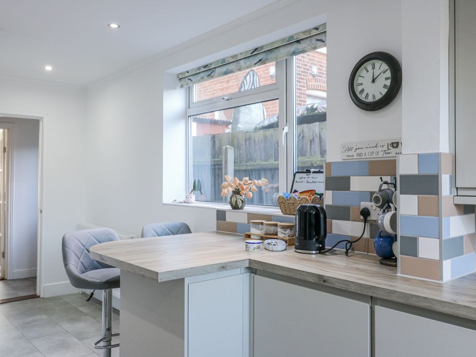 A kitchen with a kettle and a vase on the table at Beachside Terrace in Harwich