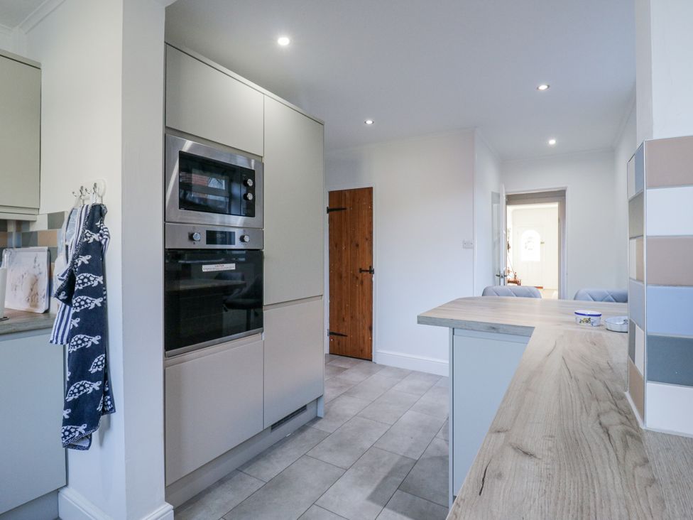 A kitchen with cabinets and appliances at Beachside Terrace in Harwich