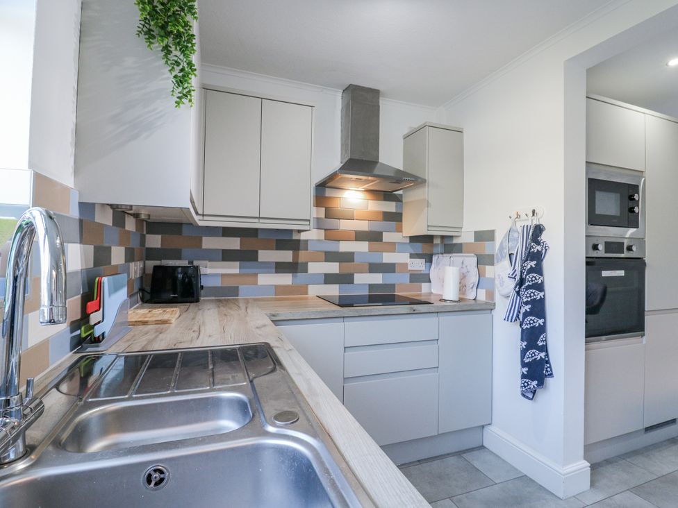 A kitchen with cabinets and appliances at Beachside Terrace in Harwich