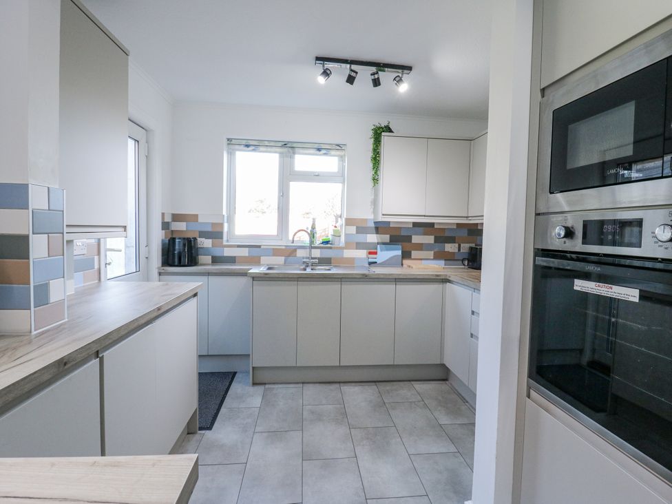A kitchen with cabinets and a sink at Beachside Terrace in Harwich