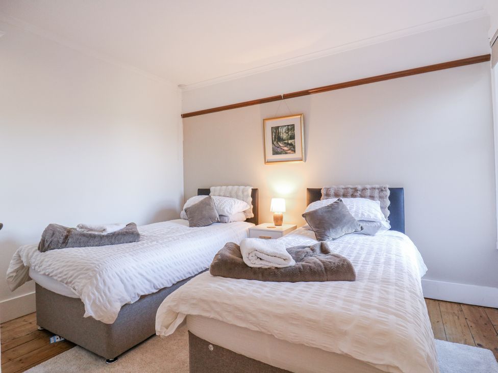 A bedroom with two beds and a lamp at Beachside Terrace in Harwich