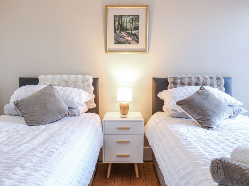 A bedroom with two beds and a nightstand at Beachside Terrace in Harwich