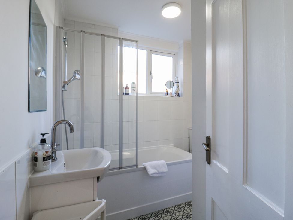 A bathroom with a bathtub and sink at Beachside Terrace in Harwich