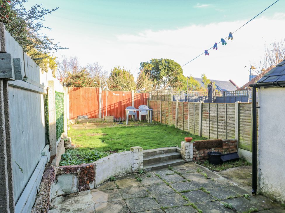 A garden with a lawn and patio area at Beachside Terrace in Harwich
