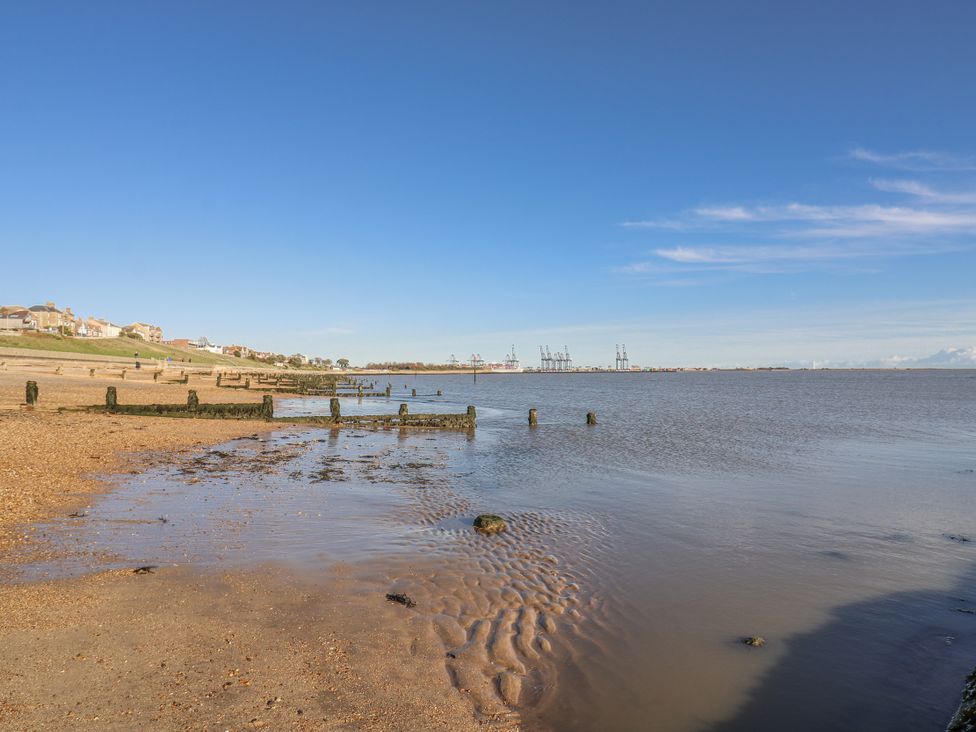 A beach view with water and houses at Beachside Terrace in Harwich