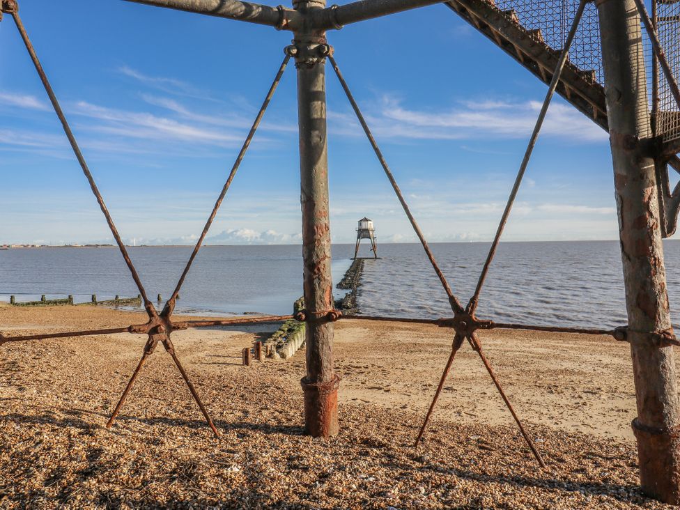 A view of a pier and lighthouse on a beach at Beachside Terrace, Harwich