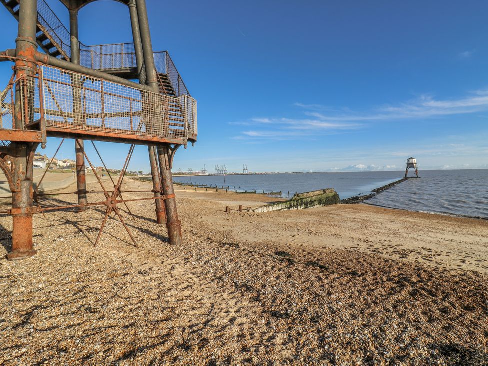 A beach with stairs and a pier at Beachside Terrace in Harwich