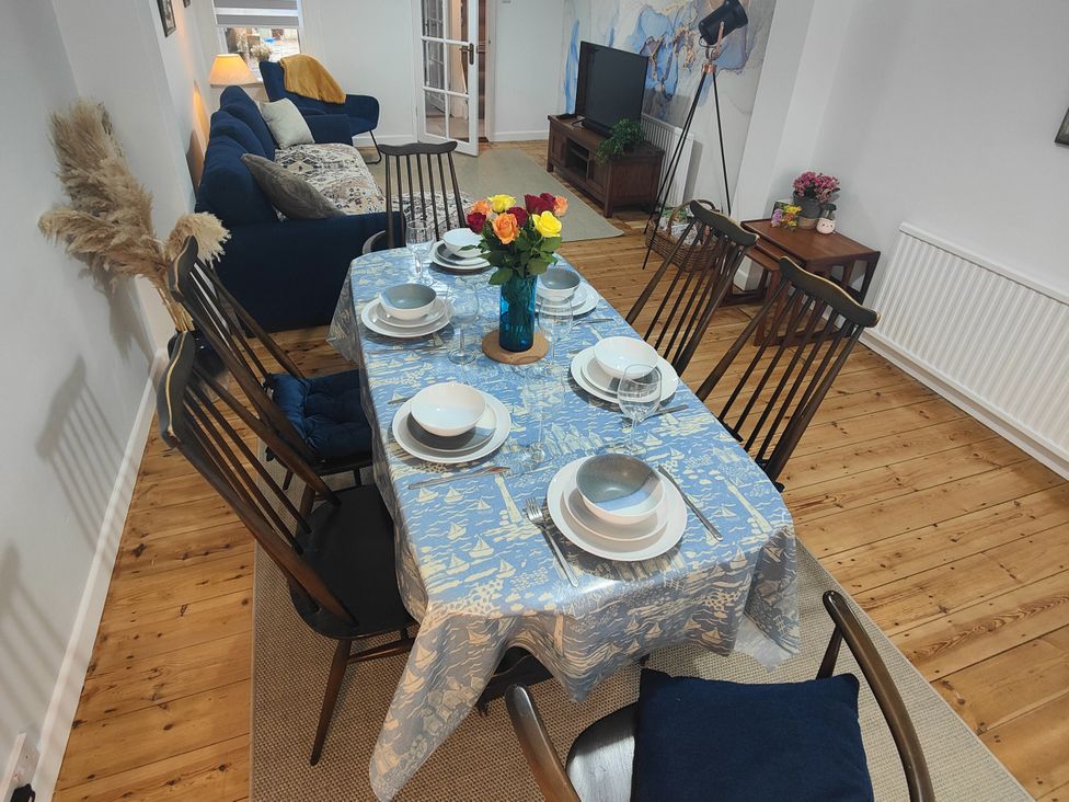 A dining room with a table set for dinner at Beachside Terrace, Harwich