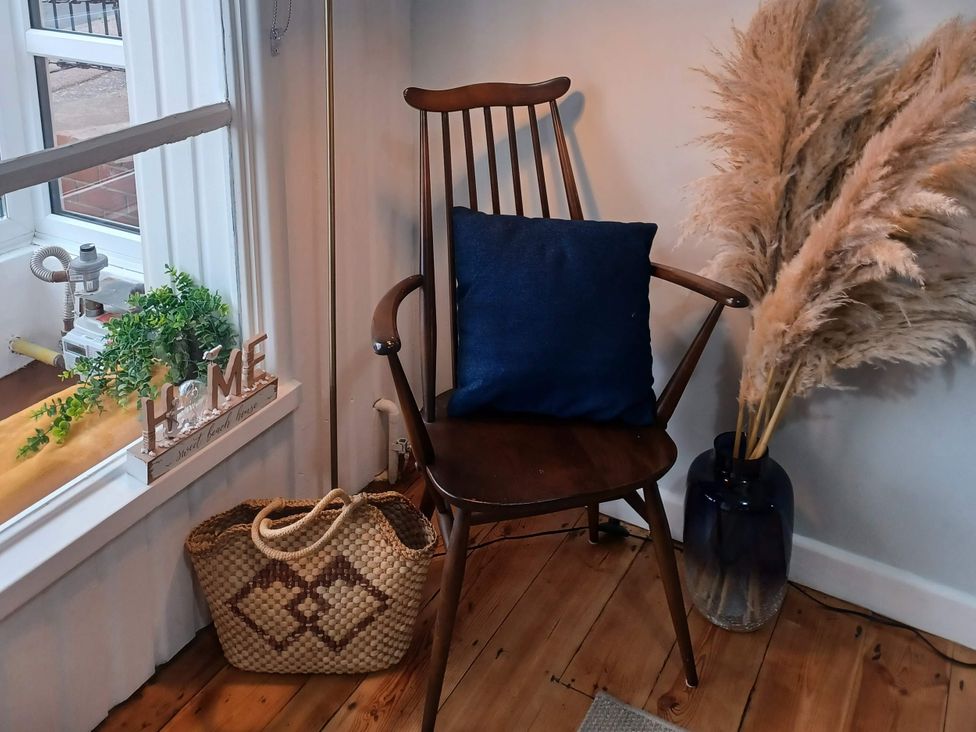 A chair with a cushion and a decorative sign at Beachside Terrace in Harwich