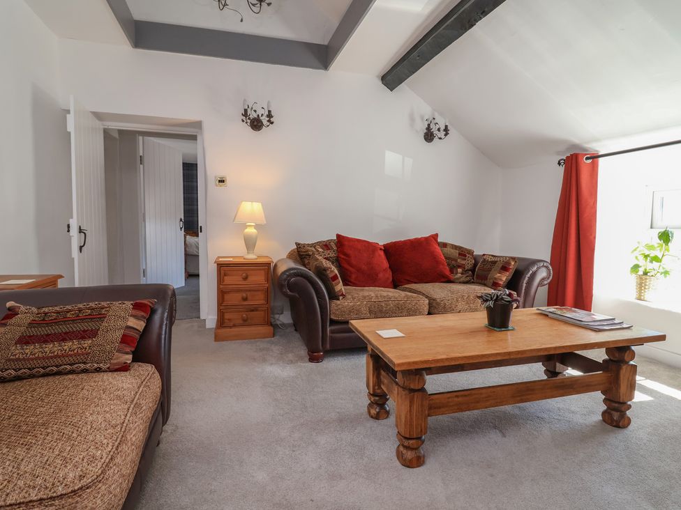 A living room with a sofa and a table at The Sun Inn Apartment in Mold