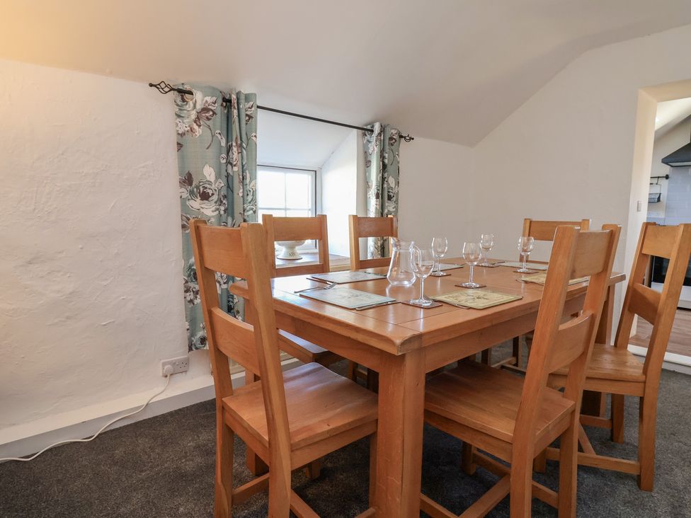 A dining room with a wooden table and chairs at The Sun Inn Apartment in Mold