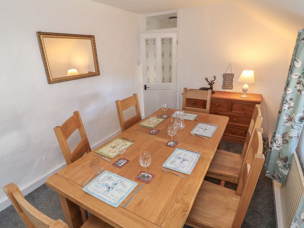 A dining room with a wooden table and chairs at The Sun Inn Apartment in Mold
