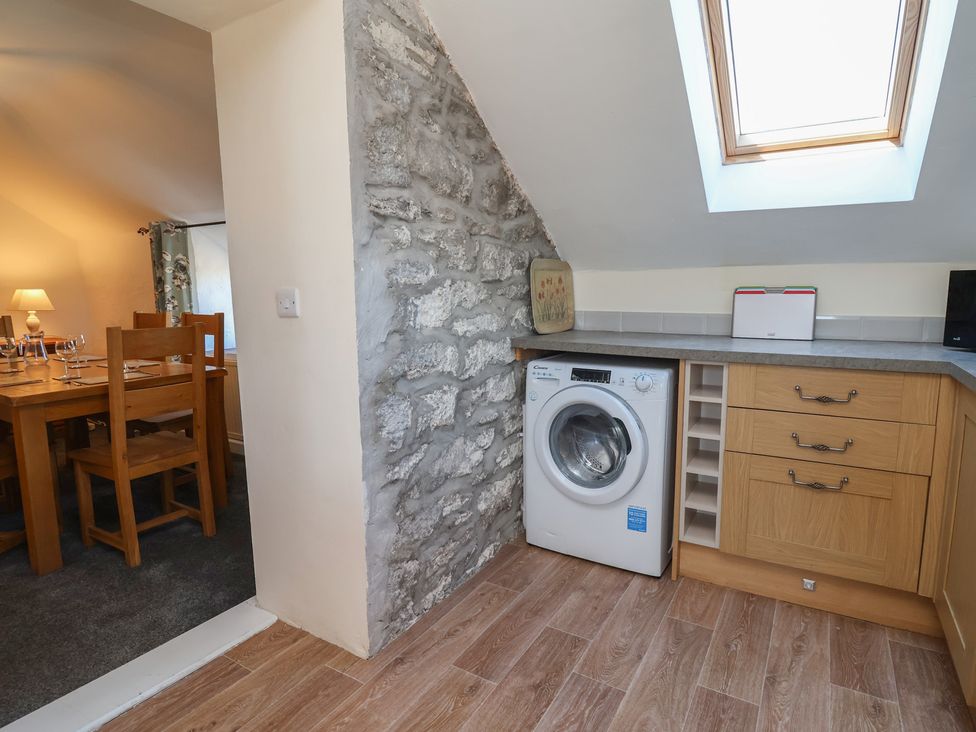 A utility room with washing machine and countertop at The Sun Inn Apartment Mold