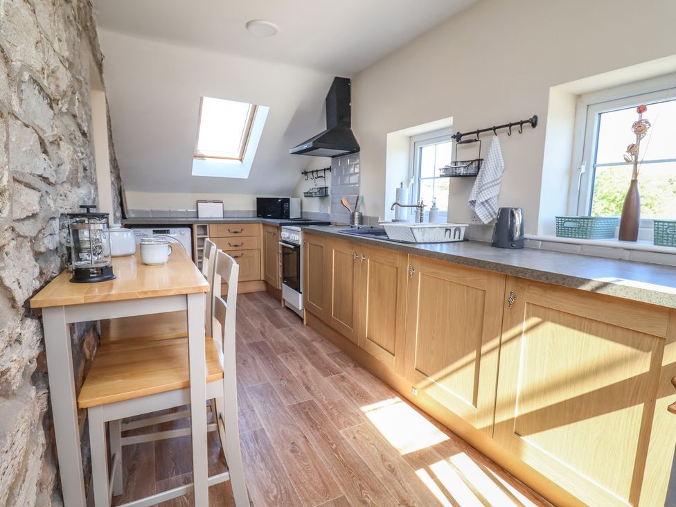 A kitchen with countertops and appliances at The Sun Inn Apartment in Mold