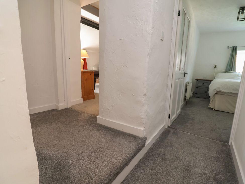 A hallway with a door and a lamp at The Sun Inn Apartment in Mold