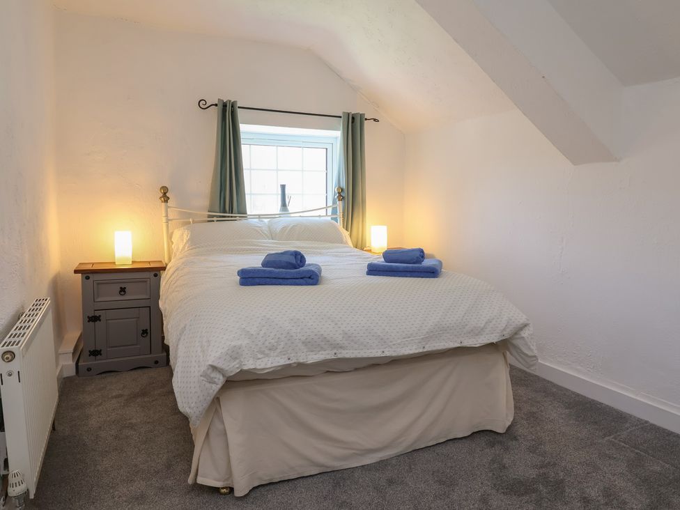A bedroom with a bed and two towels on it at The Sun Inn Apartment in Mold
