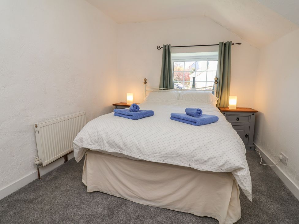 A bedroom with a bed and towels on top at The Sun Inn Apartment in Mold