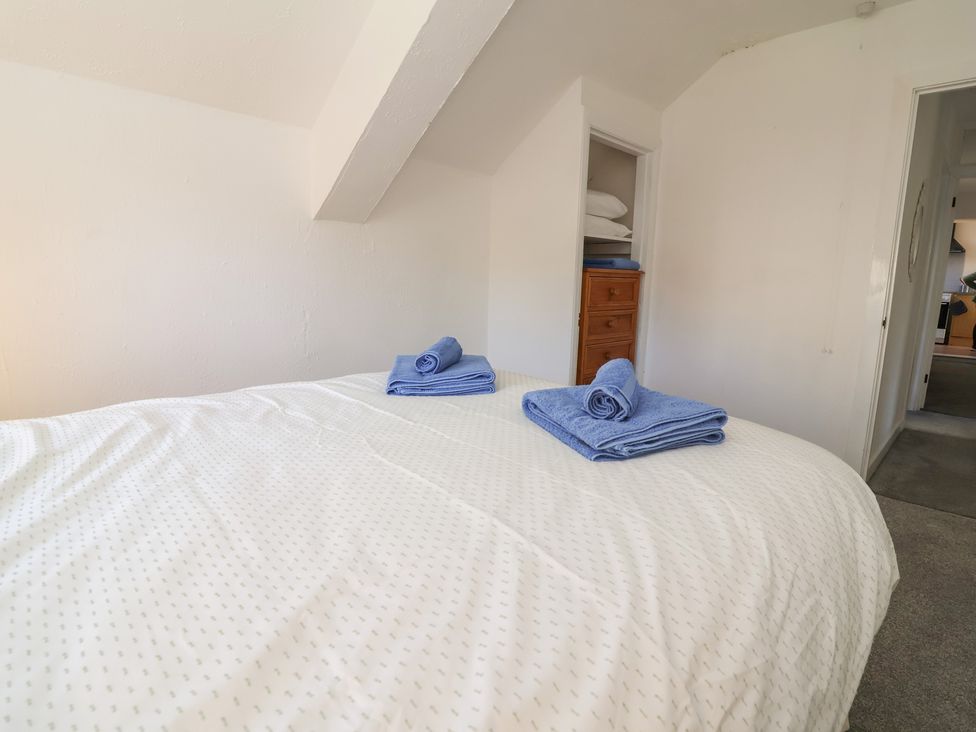A bedroom with a bed and towels at The Sun Inn Apartment in Mold