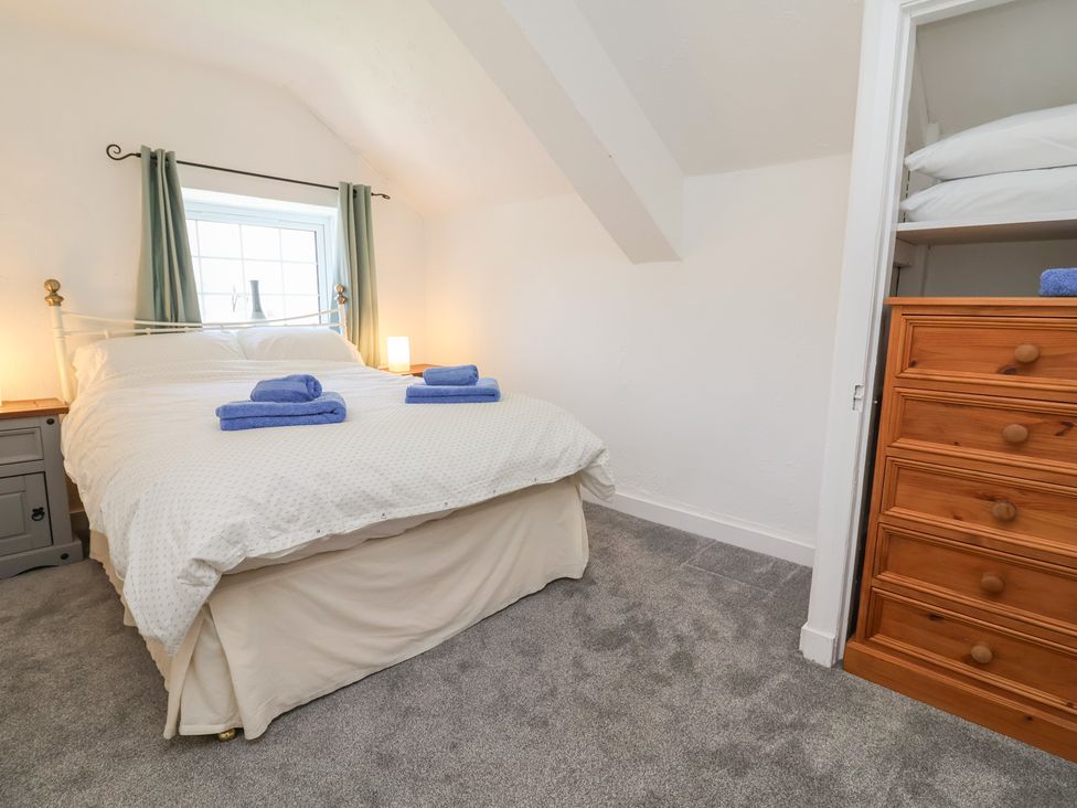 A bedroom with a bed and dresser at The Sun Inn Apartment in Mold