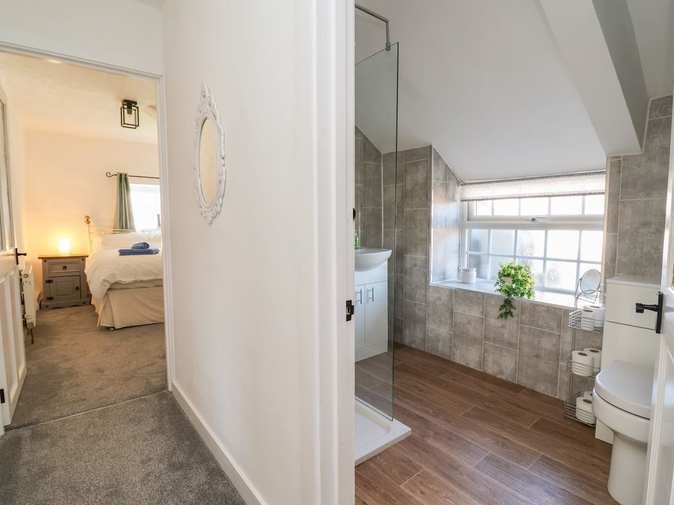 A bathroom with a shower, sink, and toilet at The Sun Inn Apartment in Mold