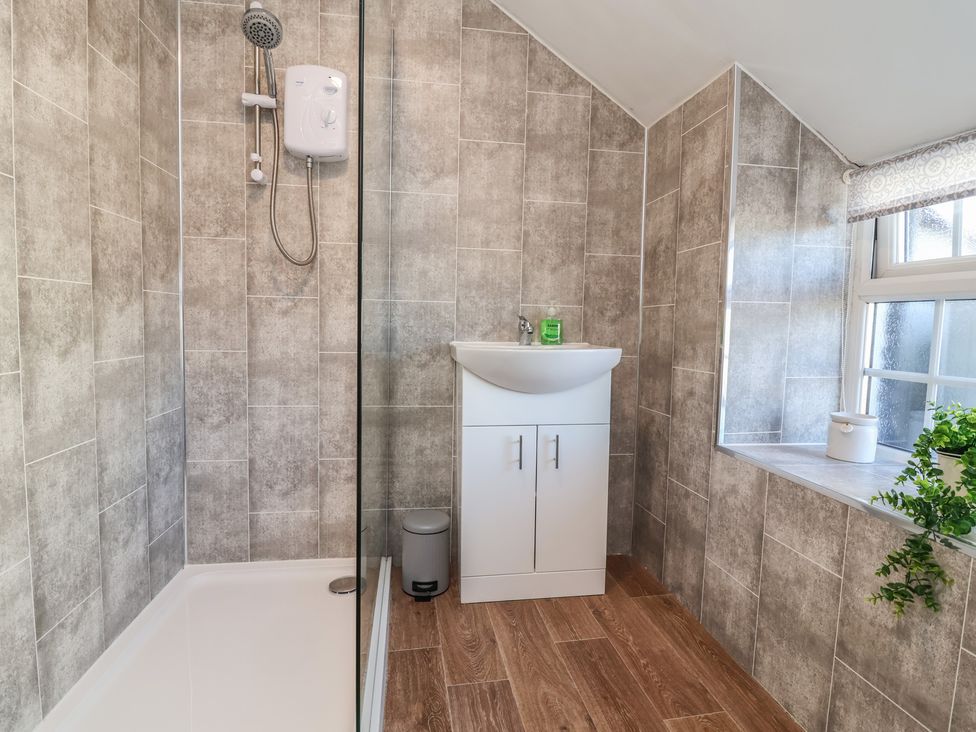 A bathroom with a shower and basin at The Sun Inn Apartment in Mold