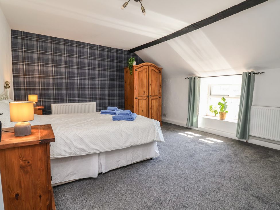 A bedroom with a bed and wardrobe at The Sun Inn Apartment in Mold