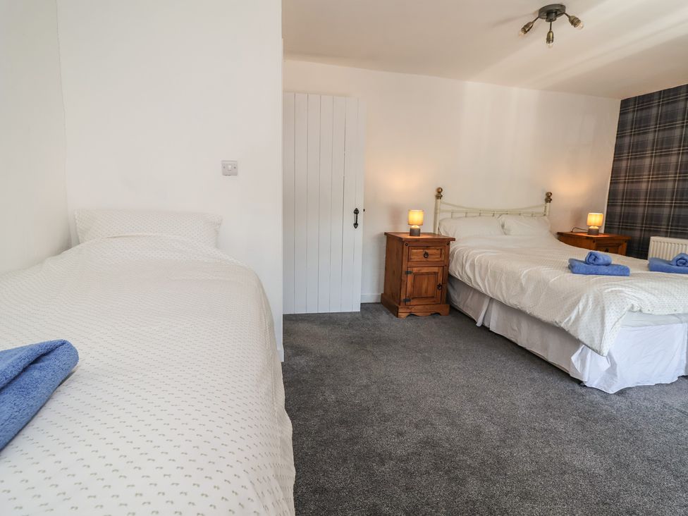 A bedroom with a single and a double bed at The Sun Inn Apartment in Mold