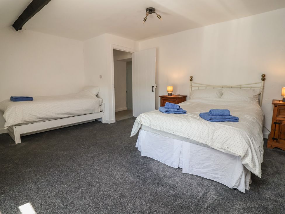 A bedroom with a double bed and a single bed at The Sun Inn Apartment in Mold