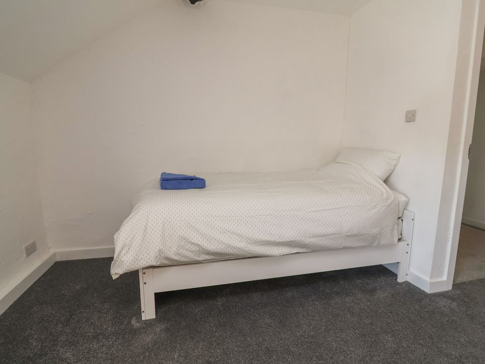 A bedroom with a bed and a towel on it at The Sun Inn Apartment in Mold