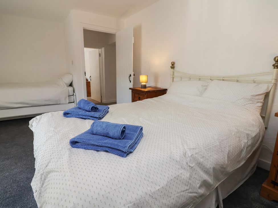 A bedroom with two beds, a lamp, and towels at The Sun Inn Apartment Mold