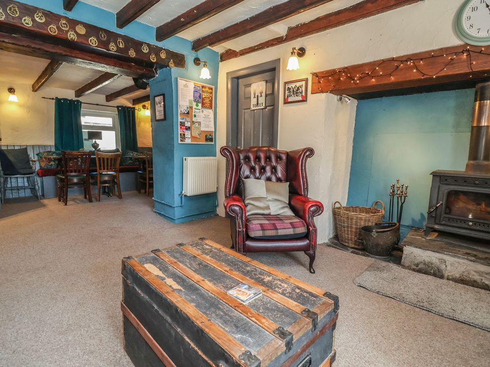 A living room with a coffee table and armchair at The Sun Inn Apartment in Mold