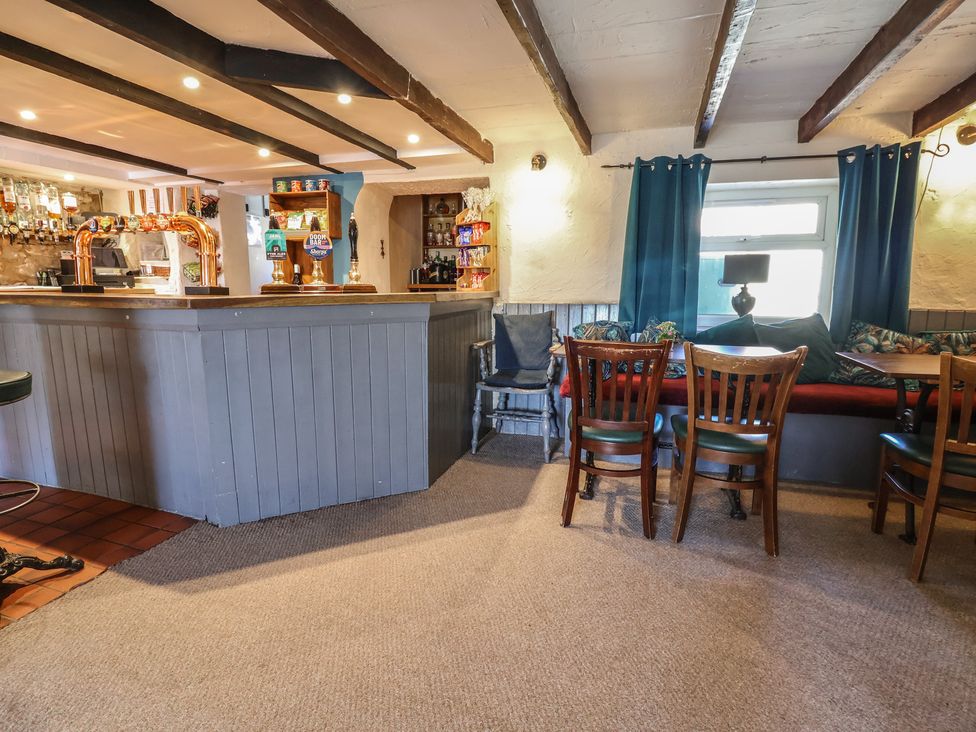 A bar area with seating and shelves at The Sun Inn Apartment in Mold
