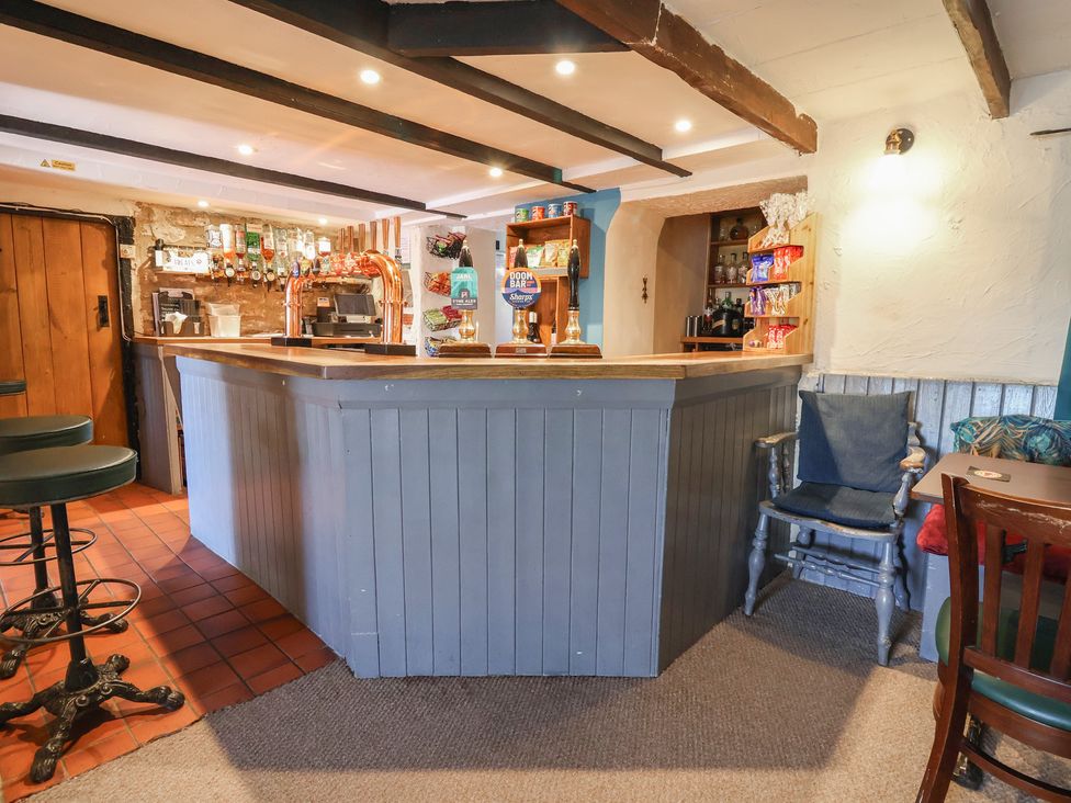 A bar area with stools and shelves at The Sun Inn Apartment in Mold