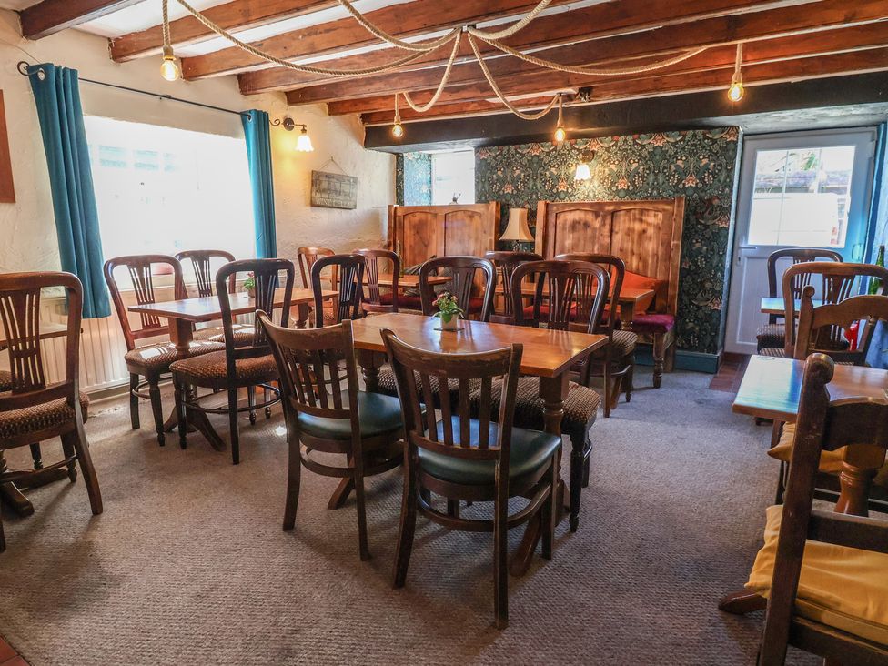 A dining room with tables and chairs at The Sun Inn Apartment in Mold