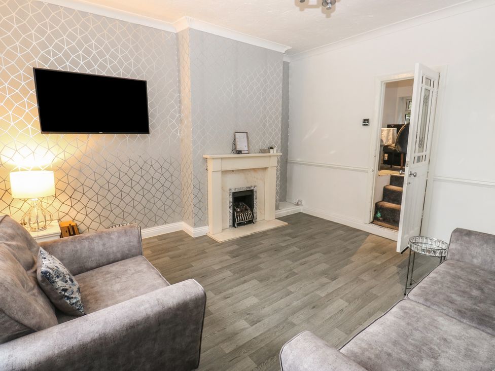 A living room with a television and fireplace at Chestnut Lodge in Bradford