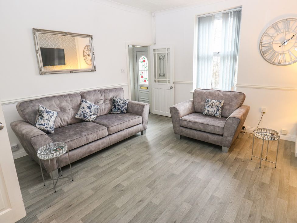 A living room with a sofa and armchair at Chestnut Lodge Bradford
