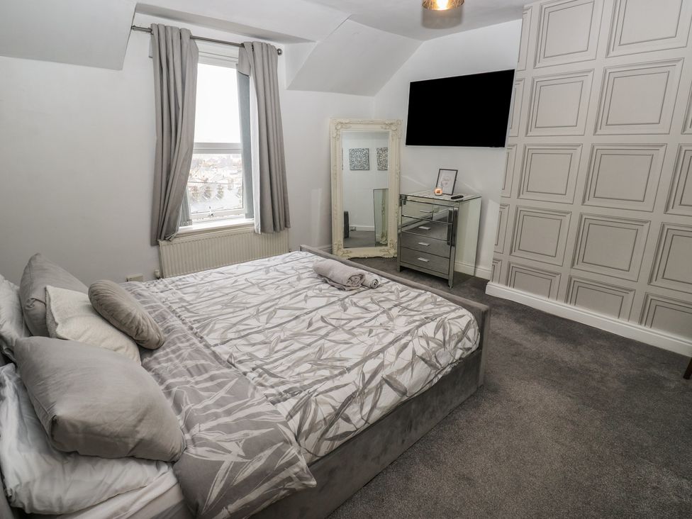 A bedroom with a bed and mirror at Chestnut Lodge in Bradford