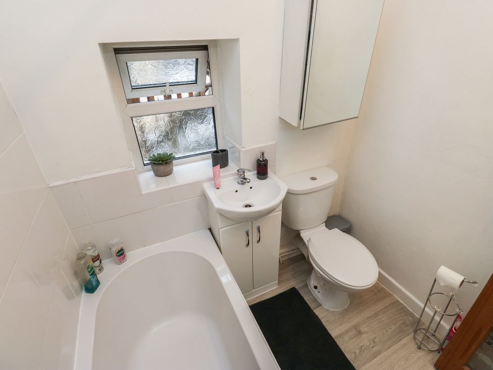 A bathroom with a bathtub, sink, and toilet at Chestnut Lodge in Bradford