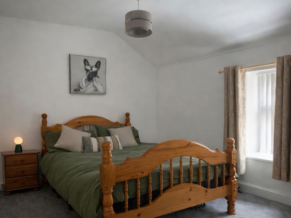 A bedroom with a wooden bed and bedside table at Chestnut Lodge Bolton Woods near Shipley