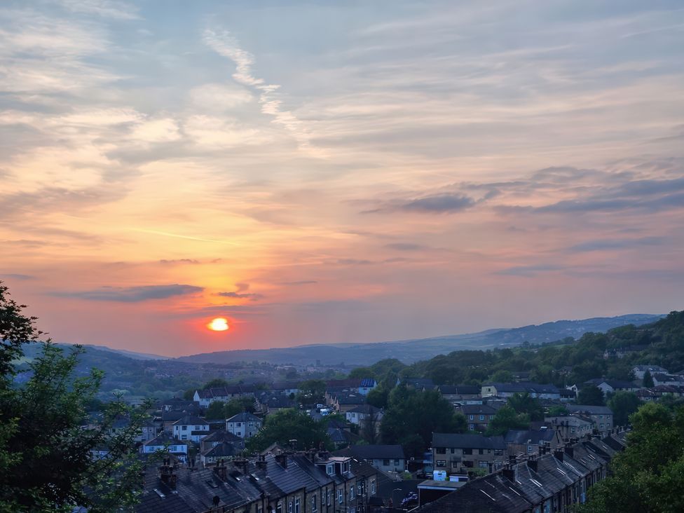 A sunset over houses and hills at Chestnut Lodge in Bolton Woods near Shipley