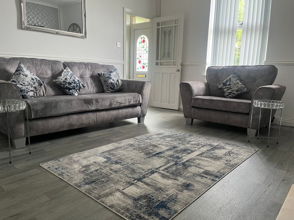 A living room with a sofa and armchair at Chestnut Lodge Bolton Woods near Shipley