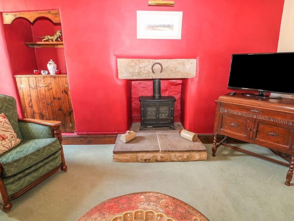 A living room with a fireplace and television at Little Bargate in Castleton, Peak District