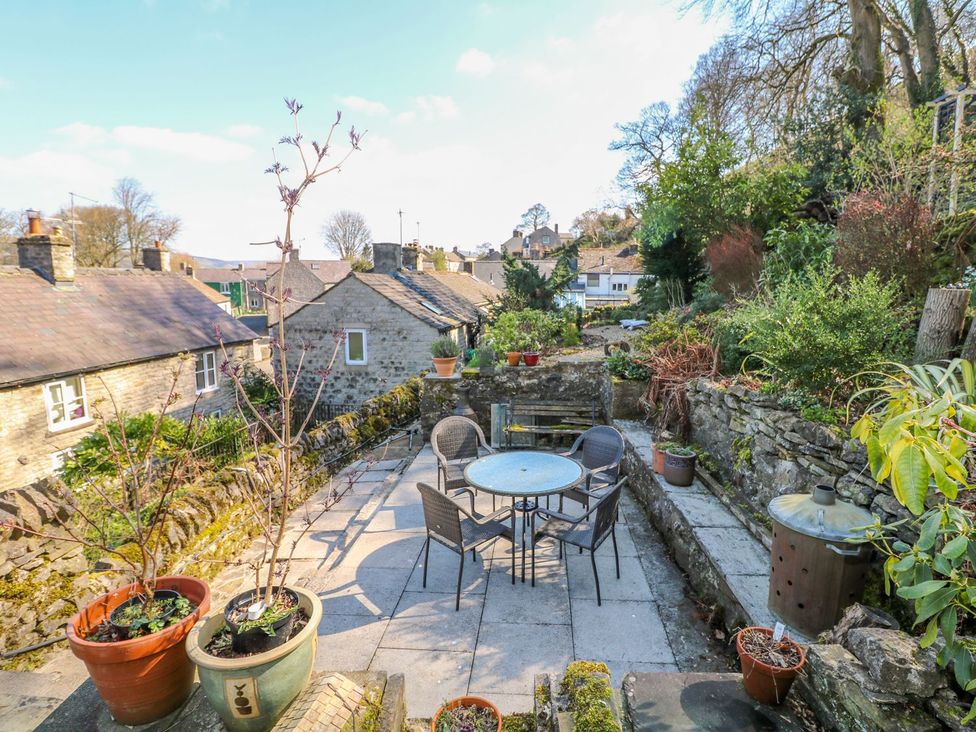 A garden with a table and chairs surrounded by plant pots at Little Bargate in Castleton, Peak District