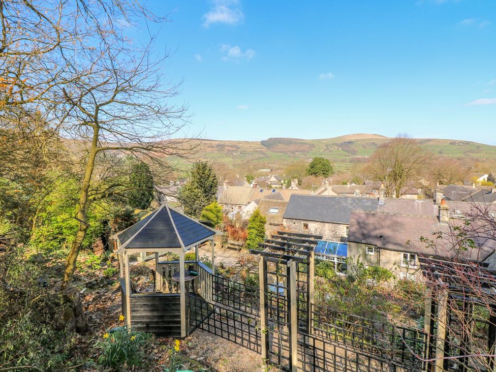 A view of a garden gazebo overlooking houses and mountains at Little Bargate Castleton, Peak District